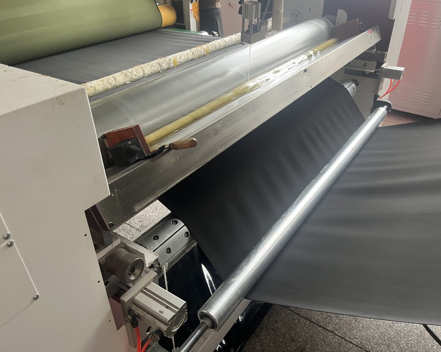 Bonding roller and doctor blade applying adhesive to the neoprene core on the laminating machine