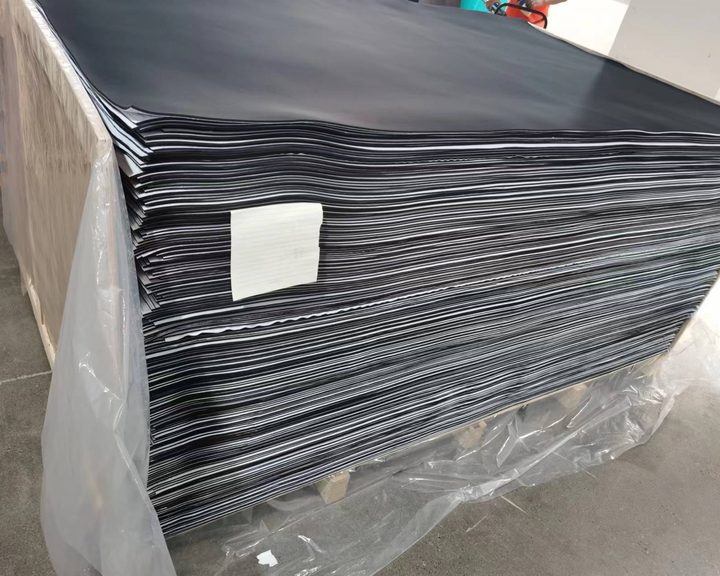 Finished neoprene sheets film-wrapped on a pallet with an inspection label, ready for dispatch
