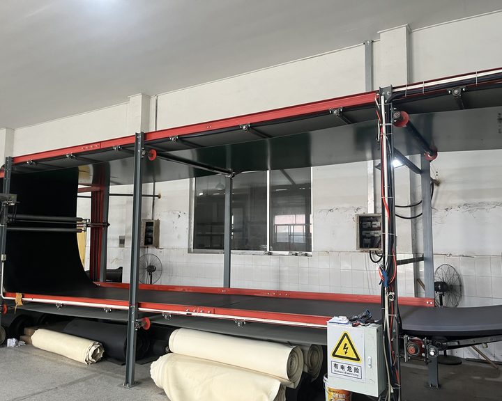 Automatic splitting machine with un-split material rolls staged beneath the bed